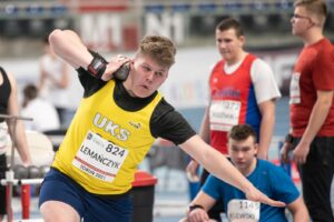 Leon Lemańczyk pchający kulą, w żółtej koszulce UKS Lipusz, w tle trzech innych zawodników