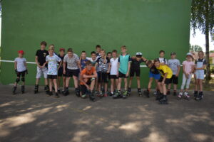 Uczestnicy warsztatów wrotkarsko-rolkarskich na stadionie sportowym w Lipuszu