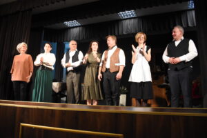 Zdjęcie aktorów po wykonie spektaklu stojących na scenie