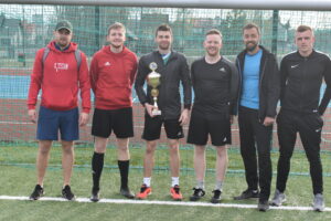 Zawodnicy stojący przy bramce do zdjęcia po turnieju piłki nożnej na orliku w Lipuszu