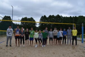 Zdjęcie zawodników po turnieju piłki siatkowej ustawionych przy siatce