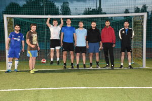 Zdjęcie zawodników turnieju piłki nożnej ustawionych do zdjęcia w bramce po turnieju