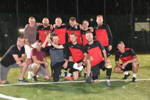 Zdjęcie zwycięskiej drużyny po turnieju piłki nożnej, mają puchar