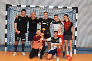 Zdjęcie zawodników po turnieju piłki nożnej z pucharem, zawodnicy stoją przy bramce