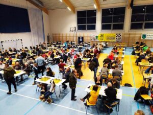 Zdjęcie ludzi podczas turnieju szachowego na hali sportowej