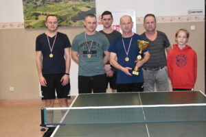 Zdjęcie 6 osób po turnieju w tenisa stołowego, 3 z nich ma medal a 1 ma puchar