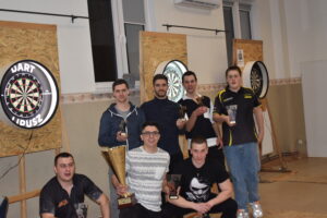 Zdjęcie grupy ludzi po turnieju, niektórzy mają w rękach nagrody