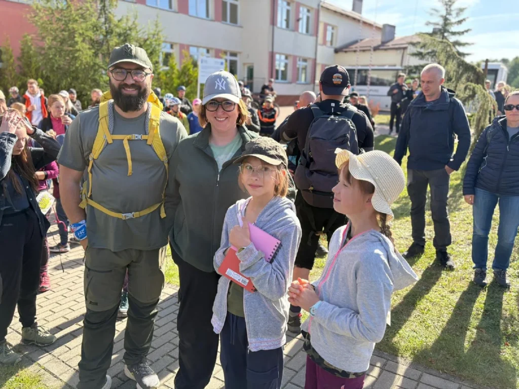 na zdjęciu grupa osób przed startem. Na pierwszym tle rodzina z dwóją dzieci