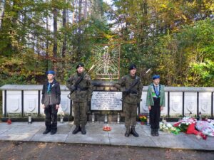 Na zdjęciu przy mogiłach pomordowanych wartę trzymają harcerze oraz żołnierze Wojska Polskiego