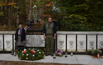 Dwóch harcerzy na grobach pomordowanych w Nowym Karpnie